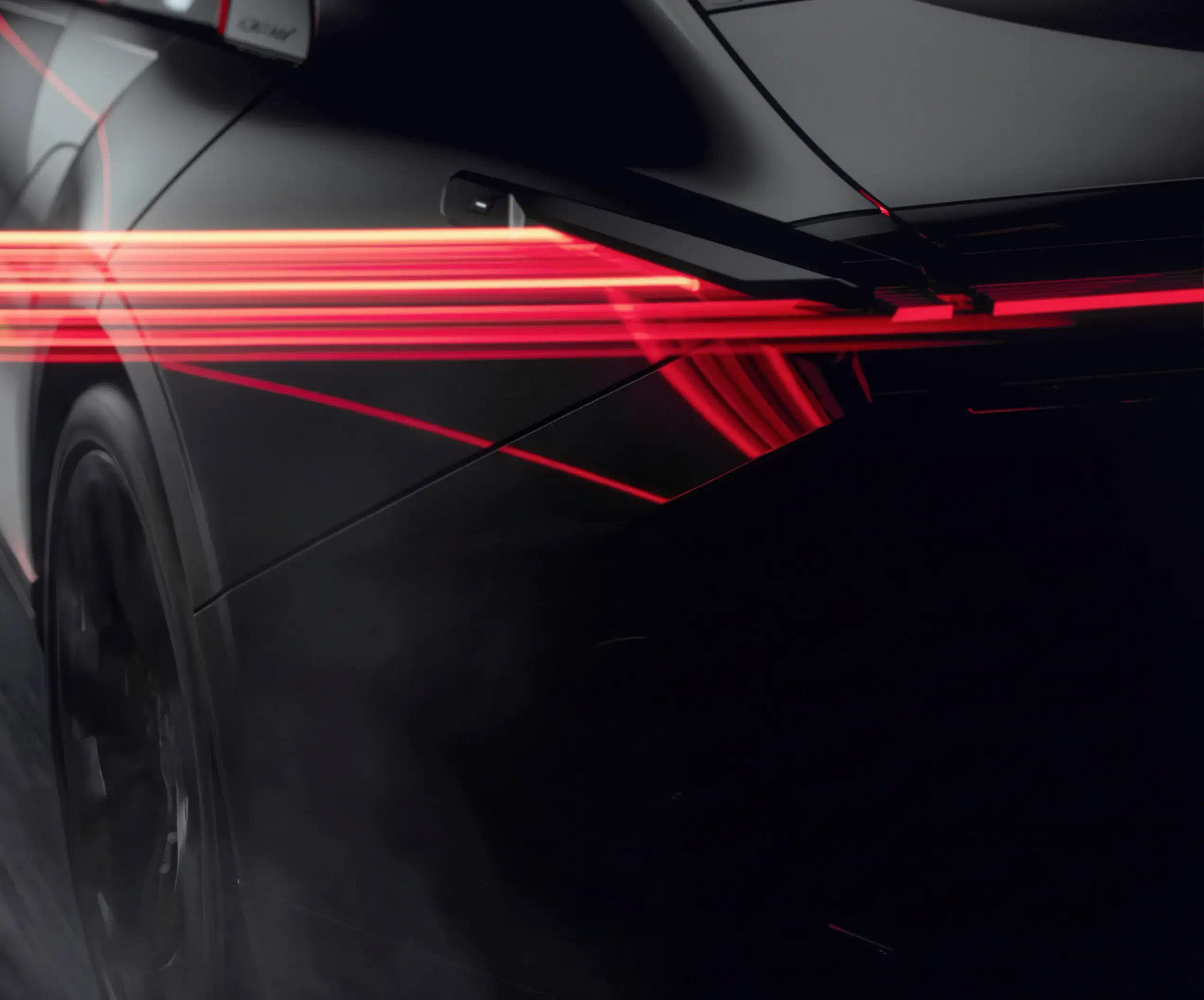 Rear of a dark car with red rear-light streaks running along its body